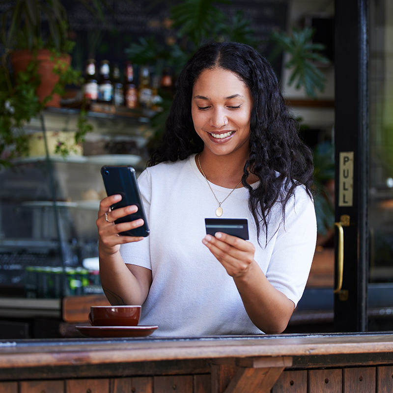 Vrouw zwart haar, met smartphone en kredietkaart